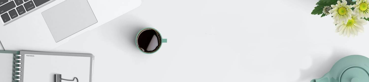 Mesa con un cafe, portatil y una libreta encima